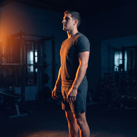A man standing after finishing a set, lit by warm light